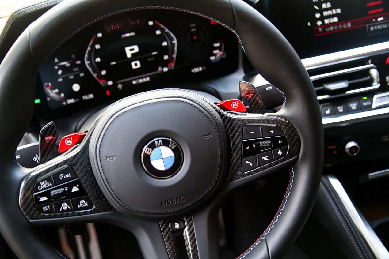 ▲M4雷霆版的方向盘充满战斗气息，除了碳纤维套件覆盖，就是最醒目的两个M自定义按键