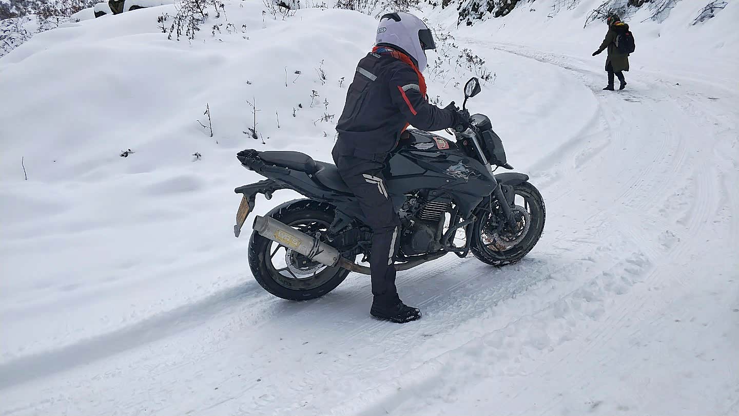 两位小姐姐居然还想骑摩托车翻夹金山，看来也只有以失败告终，摩托车轮胎打滑，压根用不上力，人都站不稳。