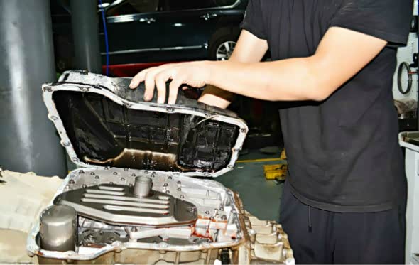 正在拆卸拆卸吉普大指挥官变速箱油底壳，下面可以清醒看到滤网和阀体。