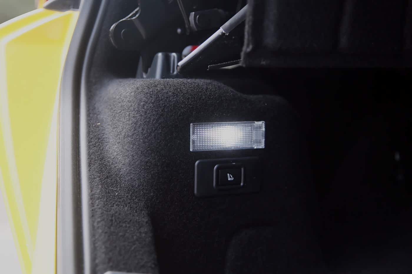 后备箱在顶篷合上的时候能容纳292升，如果不够，按下图中的按钮，可以解锁后排座椅靠背，与后备箱联通