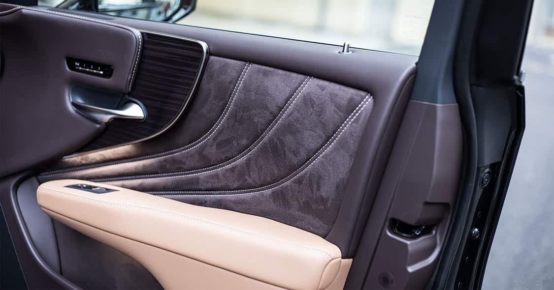 匠心还展现在缝线位置，车门上弯曲的缝线与车门门板的轮廓都是一致的，而且面料一直延伸到储物格位置