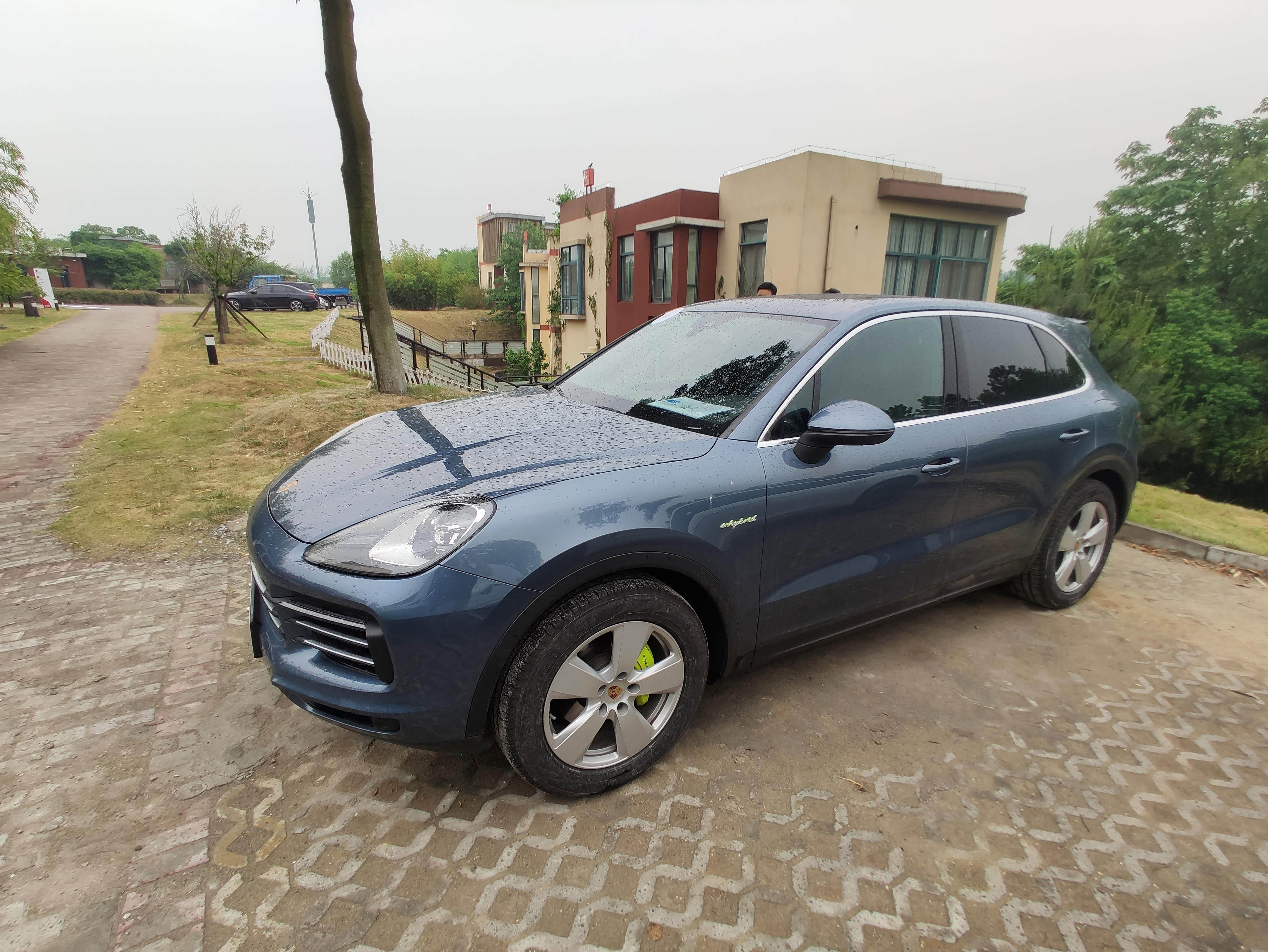 而旁边混动版卡宴显得低调很多，不仅仅是轮毂的样式，还有淡蓝色的车漆。