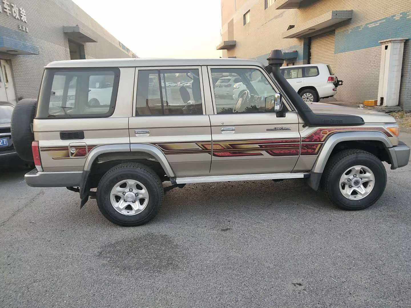 车身侧面的造型十分简洁，高高耸立的涉水喉，较高的车身离地间隙，都保证了它极高的越野通过性。